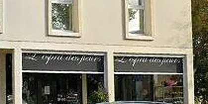 La devanture de L'Esprit des Fleurs : deux vitrines surmontées d'un bandeau noir portant l'enseigne calligraphiée